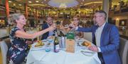 Two couples dine in the Garden Restaurant at Potters Resorts Hopton-on-Sea